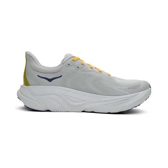 Hoka Arahi 8 herre løbesko i Stardust/Cosmic Grey har en hvid og grå farve med kraftig, skulptureret sål samt mørkeblåt Hoka-logo på siden. Skoen præsenteres på en ensfarvet hvid baggrund.