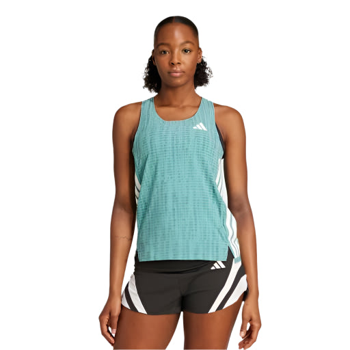 En person ser frem for sig i en blågrøn Adidas Adizero Singlet, Dame, Powtea/Pretea, med hvidt logo og sorte shorts med hvide geometriske striber, der står på en almindelig hvid baggrund.