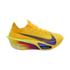 Nike Alphafly Next% 3 Dame i Laser Orange/Indigo Burst-Citron Pulse har en livlig gul og orange overdel med en lilla swoosh, tyk sål og gradueret mellemsål, vist mod en almindelig hvid baggrund.