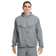 En mand med kort mørkt hår og et neutralt udtryk ser frem for sig iført en Nike Repel UV Running Jacket, Herre, i Smoke Grey/Smoke Grey/Reflective Silv, med lynlås foran, vinklede brystklapper og elastiske manchetter.