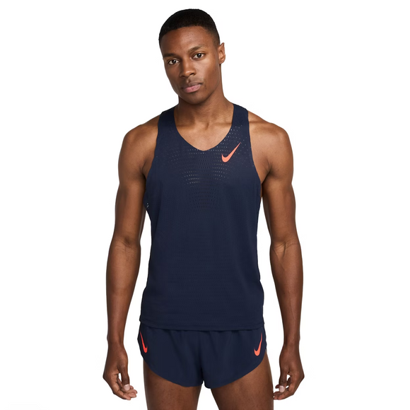 En mand står med front mod en hvid baggrund iført Nike AeroSwift Running Singlet, Herre, i Obsidian/Bright Crimson og matchende shorts, der fremhæver premium herre løbetøj.