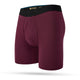 Stance Fig Boxer Brief til herrer i rødbrun har en sort logo-linning, kontureret pose og synlige syninger, vist på en hvid baggrund.