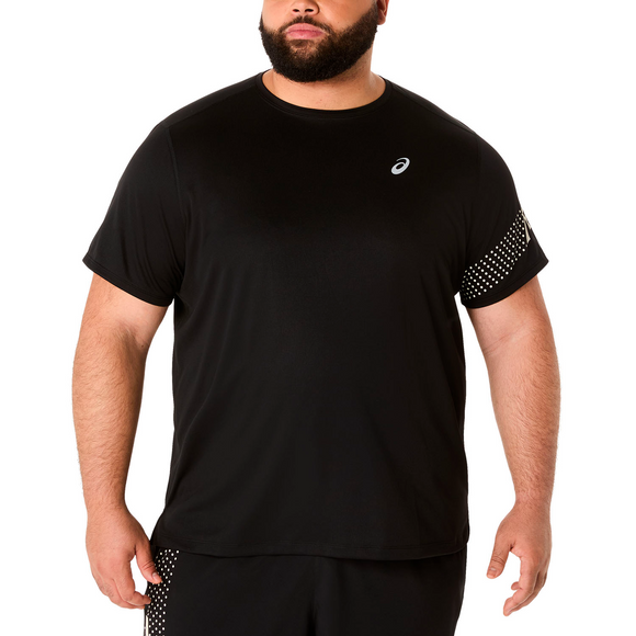 En mand er iført Asics Icon SS Top, Herre, Performance Black - med et lille hvidt logo på venstre bryst og et prikket mønster på højre ærme - sammen med sorte shorts på en almindelig hvid baggrund.