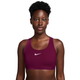 En person iført en Nike polstret sports-BH, Dame, True Berry/White, med et mørkt bærfarvet, polstret design og et hvidt Swoosh-logo.
