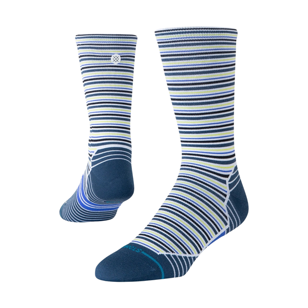 Et par Stance Bert UL Crew-sokker i unisex-farven lysegrøn med vandrette striber i hvid, marineblå, lyseblå og gul. De er designet med henblik på åndbarhed og komfort under træning; den ene sok er vist opretstående, mens den anden er vinklet for at vise hælen og sålen. Begge sokker vises på en ensfarvet hvid baggrund.