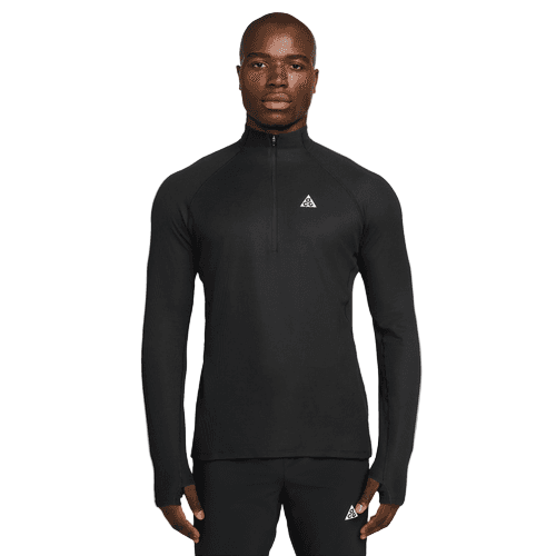 En person er iført en Nike ACG Half-Zip Running Top til mænd i Black/Black/Summit White sammen med matchende sorte bukser; begge beklædningsgenstande har et lille trekantet logo, mens personen står med ansigtet fremad mod en almindelig hvid baggrund.