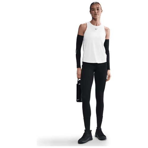 En person står på en hvid baggrund iført en Nike Dri-FIT Classic Tank Top, Dame, i hvid/sort, sammen med sorte leggings, sorte ærmer, sorte sportssko og med en sort vandflaske i højre hånd.