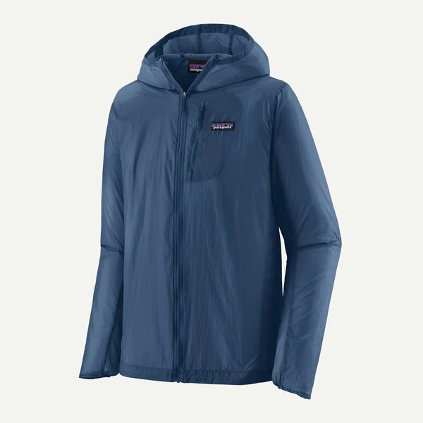 Patagonia Houdini Jkt, Herre, Clement Blue er en ultralet vindjakke med lynlås foran, lille brystlomme og diskret logo på venstre bryst. Perfekt som herre løbejakke, vist mod en helt hvid baggrund.