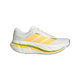 Et billede set fra siden af Adidas Adistar BYD 2 herreløbesko i farvekombinationen CLOWHI/LUTA/SIGGNR, der har et hvidt sportsligt design med gule og orange striber, grønne detaljer ved snørebåndene, en tyk, polstret sål med responsiv dæmpning samt sorte og gule accenter på mellemsålen, vist på en hvid baggrund.