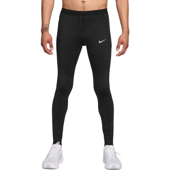 En person iført Nike Stride Running Tight, Herre, Black/Reflective Silv og hvide sneakers står på en almindelig hvid baggrund. Kun underkroppen og benene er synlige.