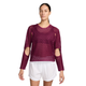En person har en mørk bærfarvet Nike Aero-FIT langærmet løbetrøje til kvinder, True Berry/Black, med udskæringer ved albuerne og skuldrene, på over en sort sports-BH, kombineret med hvide sportsshorts.