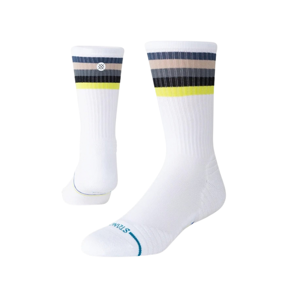 Stance Line Up Mid Ribbed Crew-sokkerne i hvid er unisex-sokker med ribmønster til hverdagsbrug, der har vandrette grå, sorte og gule striber nær toppen, et lille cirkulært logo samt lyseblå detaljer på tåen og tekst nær fodområdet.