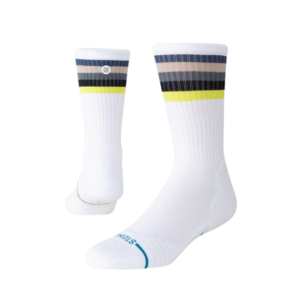 Stance Line Up Mid Ribbed Crew-sokkerne i hvid er unisex-sokker med ribmønster til hverdagsbrug, der har vandrette grå, sorte og gule striber nær toppen, et lille cirkulært logo samt lyseblå detaljer på tåen og tekst nær fodområdet.