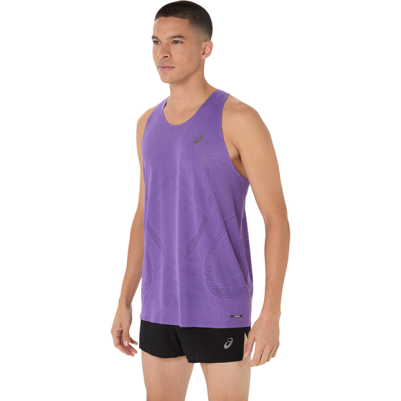 En mand står lidt sidelæns i en Asics Metarun Singlet, Herre, Edo Purple og sorte shorts - ideel til løbetræning - mod en almindelig hvid baggrund.