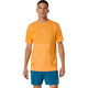 En mand kigger fremad iført Asics Road Seamless Ss Top, Herre, Yamabuki - en orange sportstrøje med et hvidt logo - og blå sportsshorts på en hvid baggrund.