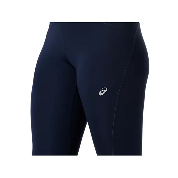 Nærbillede af en person iført Asics Road High Waist Tight, Dame, Midnatsmørkeblå tights med et lille sølvlogo på låret, fremstillet af genbrugsmaterialer.