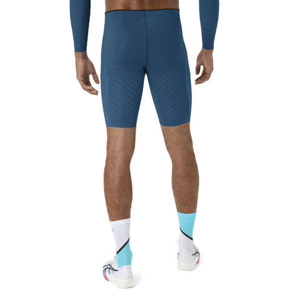 Der ses en person set bagfra, iført en blå langærmet cykeltrøje, Asics Metaspeed Tights Herre i farven Rich Navy, hvide og lyseblå strømper samt hvide cykelsko, foran en ensfarvet hvid baggrund.