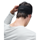 En person i en hvid langærmet skjorte med det sorte On Core Headband, set bagfra med en hånd på hovedet. Perfekt til løb.