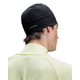 En person iført en sort On Core Beanie, Unisex, med On-logoet på siden og en lysegul, varmt tonet jakke, set bagfra mod en hvid baggrund.