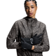 En kvinde iført On Core Glove touchscreen-handsker i sort og en jakke.