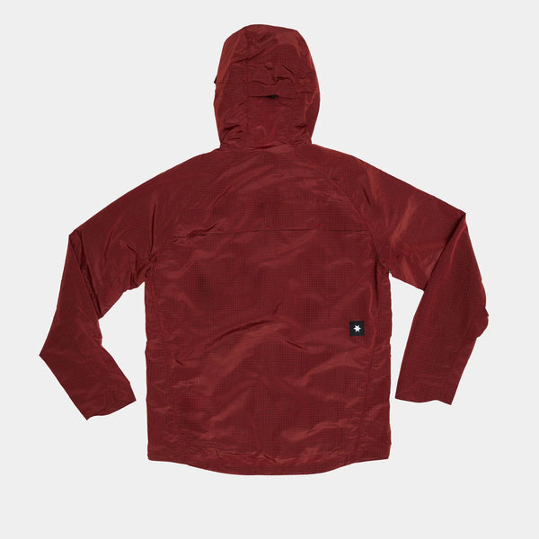 En Saysky Clean Pace Shield Jacket, Herre, Red ligger fladt med forsiden nedad på en hvid baggrund. Den har lange ærmer, en synlig søm øverst på ryggen og et lille, sort, rektangulært mærke nær den nederste kant.