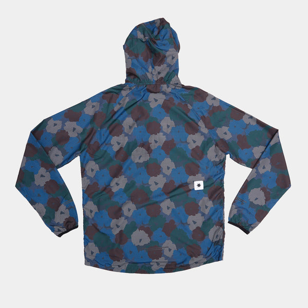 Saysky Flower Pace Jacket, Herre, Blå Aop: Let vindtæt jakke med blomstermønster i blå, grøn og brun, vist fladt med bagsiden opad. En lille hvid tag med sort stjerne er syet nær bundkanten.
