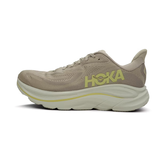 Hoka Clifton 10 herre løbesko i Raw Linen/Stone har en tyk, hvid sål, gult HOKA-logo på siden og er lavet af mesh og syntetiske materialer for letvægtskomfort. Designet ses fra venstre side og har snørelukning.