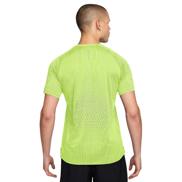 En person iført en lysegul, kortærmet Nike Stride Aero-FIT løbetrøje til mænd, farven Lt Lemon Twist/Reflective Silver, med et struktureret, ventileret rygpanel.