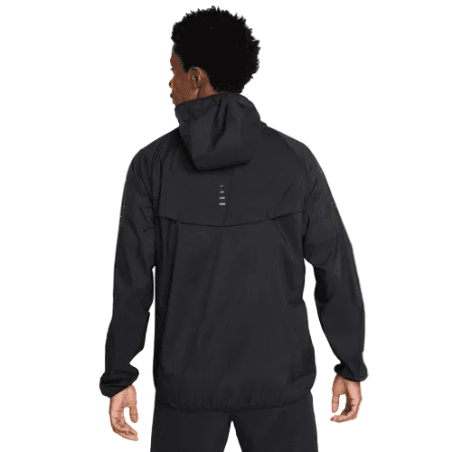 En person iført Nike Stride Repel UV Running Jacket, Herre, Black/Black/Reflective Silv ses bagfra mod en hvid baggrund. Jakken har en løs pasform, lange ærmer og diskrete refleksdetaljer på den øverste del af ryggen.