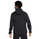 En person iført Nike Stride Repel UV Running Jacket, Herre, Black/Black/Reflective Silv ses bagfra mod en hvid baggrund. Jakken har en løs pasform, lange ærmer og diskrete refleksdetaljer på den øverste del af ryggen.
