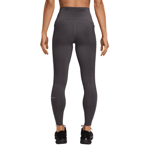 En person står med ryggen til kameraet iført Nike Swift High-Waisted 7/8 Running Tights med lommer i Thunder Grey/Reflective Silver med synlige sømme, et lille logo nær venstre ankel og en slank, atletisk pasform.
