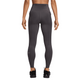 En person står med ryggen til kameraet iført Nike Swift High-Waisted 7/8 Running Tights med lommer i Thunder Grey/Reflective Silver med synlige sømme, et lille logo nær venstre ankel og en slank, atletisk pasform.