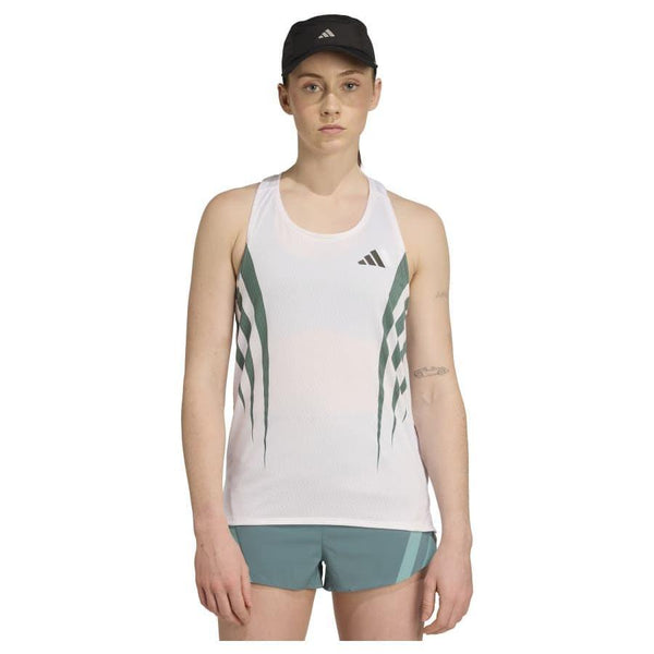 En person iført sort Adidas-kasket, hvid/preloved teal Adizero Archive Running Singlet (Dame) og grønne shorts står frontvendt mod en ensfarvet hvid baggrund.