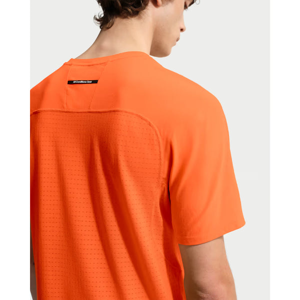 En mand ses bagfra iført en Nike ACG Dfadv Solar Chase SS i Safety Orange/Summit White med ventilationshuller i mesh og et lille sort mærke ved halsen - ideel til udendørs træning.