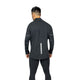 En person står med front mod kameraet iført sorte bukser og en LiiteGuard Hydro-Tech Running Jacket, Herre, Black. Jakken har vandrette refleksstriber på hvert ærme og en lodret refleksstribe nederst på ryggen.