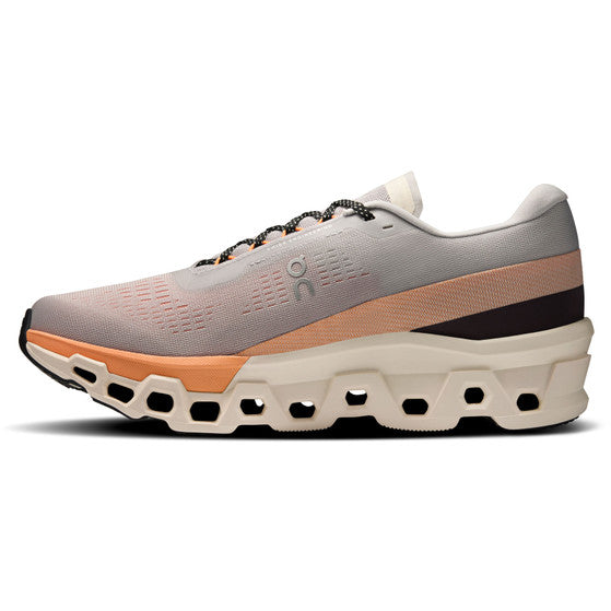 Sidebillede af On Cloudmonster 2, Herre, Glacier/Tangerine: lysegrå og orange overdel, sorte snørebånd og en fed hvid sål med geometriske udskæringer for optimal komfort og et moderne look.