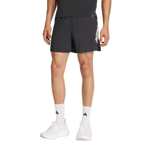 En person i sort T-shirt, Adidas Adi365 Shorts, Herre, Black med hvide striber, hvide strømper og hvide sneakers står på en ensfarvet baggrund - ideel til løb og fitness.