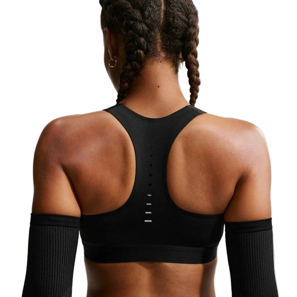 En kvinde iført en sort og sølvfarvet Nike Swift Hs BH med høj støtte.