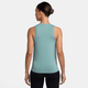 En person vender ansigtet væk fra kameraet iført en Nike Dri-FIT Classic Tank Top til kvinder i Cannon/White og sorte leggings. Håret er sat op i en pæn knold på en almindelig hvid baggrund.