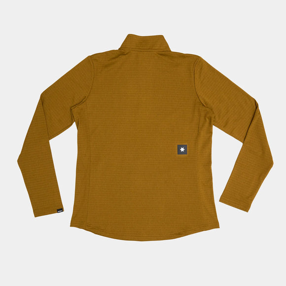 En langærmet Blaze Half Zip Light Fleece, Dame, Camel fra Saysky er lagt fladt med bagsiden opad. Et lille rektangulært mærke med en hvid stjerne accentuerer nederst til højre og fremhæver dette let tekniske mellemlag.