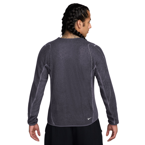 Bagfra-billede af en mand iført en mørkegrå Nike-trøje med rund hals og lange ærmer samt synlige sømdetaljer.