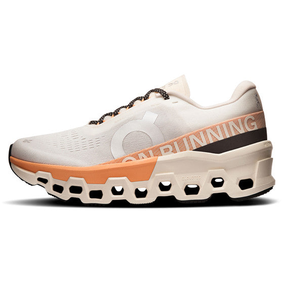 On Cloudmonster 2 Dame i Ivory/Tangerine er en beige atletisk løbesko til damer med orange og sorte detaljer, Helion superfoam sekskantet sål, overdel i mesh, ON RUNNING-branding og sort-hvide snørebånd, der giver stil og komfort.