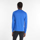 En mand kigger væk fra kameraet og er iført New Balance Athletics Long Sleeve, Herre, i Blue Gemstone Heather med sorte bukser på en almindelig hvid baggrund.