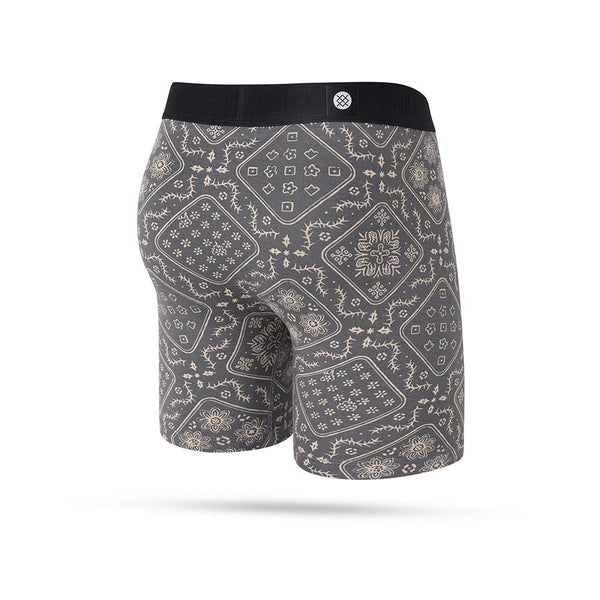 Stances It Is Paisley Wholester boxershorts herre i Stringgrey har en grå bund, beige paisley-blomstermønster, sort linning og fugttransporterende stof, vist på en almindelig hvid baggrund.