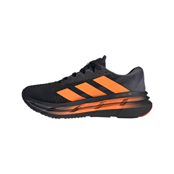 Adistar Byd fra Adidas er en herreløbesko i sort med orange detaljer, tyk polstret sål for komfort og åndbart mesh. Modellen vises fra siden mod en hvid baggrund. Farve: Cblack/Luor/Auon.