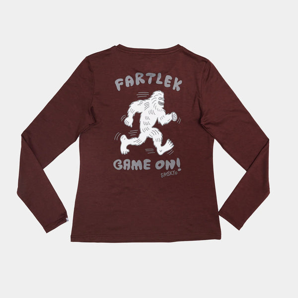 Saysky W Statement Pace Long Sleeve, Dame, Red er en rødbrun sportstop med en hvid tegnet Bigfoot, der løber med teksten "FARTLEK GAME ON!". Perfekt som hurtigtørrende træningstrøje til aktive kvinder.