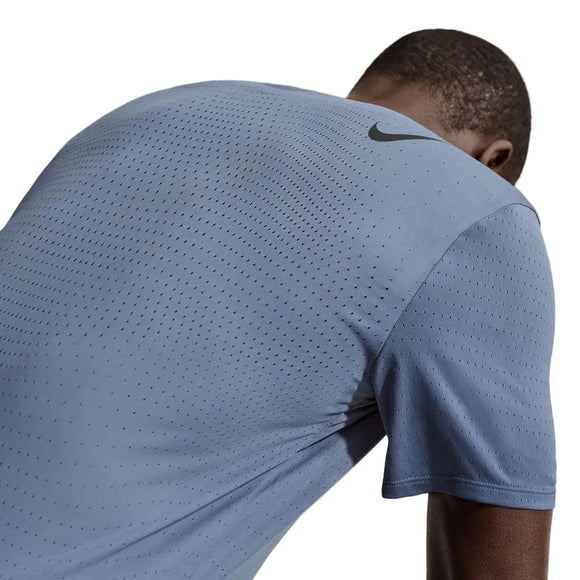 En mand ses bagfra iført Nike Dfadv Aroswft SS Top, Herre i Diffused Blue/Black med et sort logo på den øverste del af ryggen, der fremhæver dette svedtransporterende løbetøj.