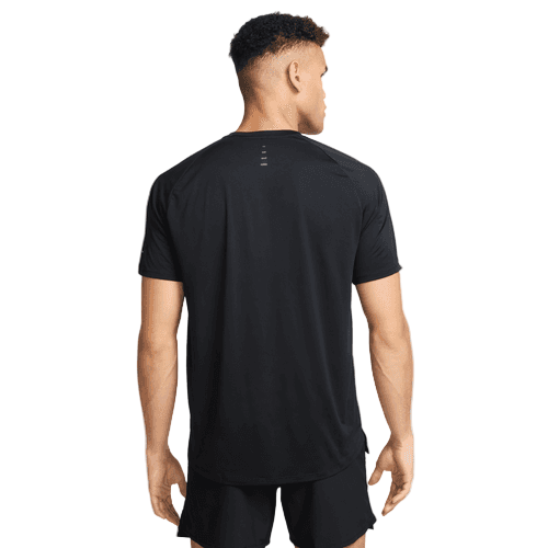 En mand står med ryggen til kameraet iført en sort Nike Stride SS løbetop til mænd med korte ærmer og fire små vandrette striber øverst midt på ryggen.