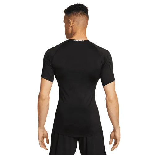 En mand ses bagfra iført en tætsiddende sort Nike Df Tight Top Ss, Herre, Black/White og matchende shorts, stående på en almindelig hvid baggrund.