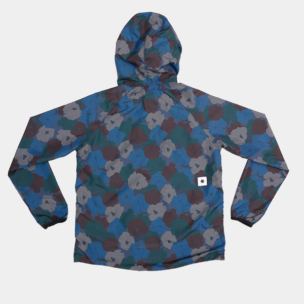 Saysky W Flower Pace Jacket, Dame, Blue Aop er vist lagt fladt bagpå. Denne løbejakke med hætte har et blåt/grønt/gråt/brunt blomstret camouflageprint, lange ærmer, åndbart materiale og et lille hvidt logo i bunden.